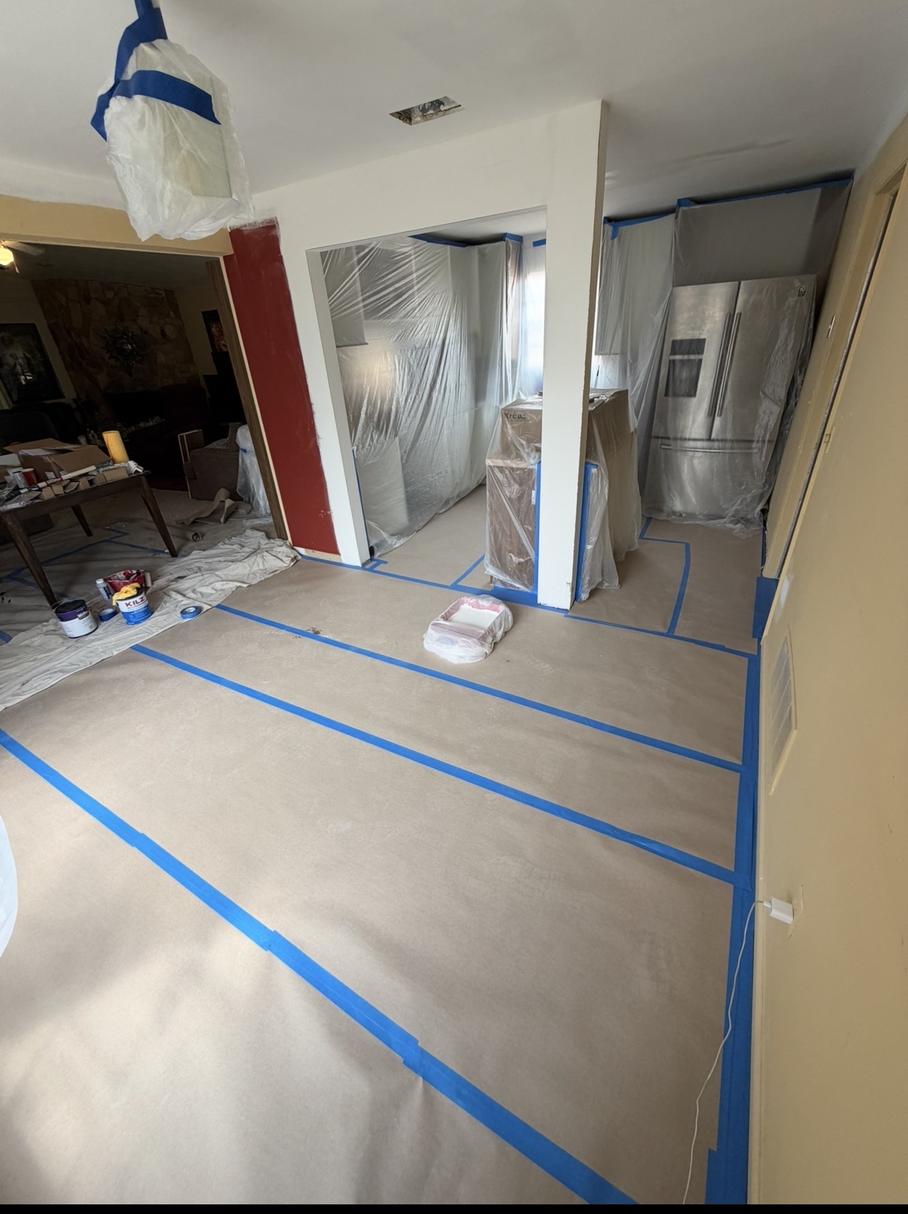 Living space prepped with plastic and rosin paper